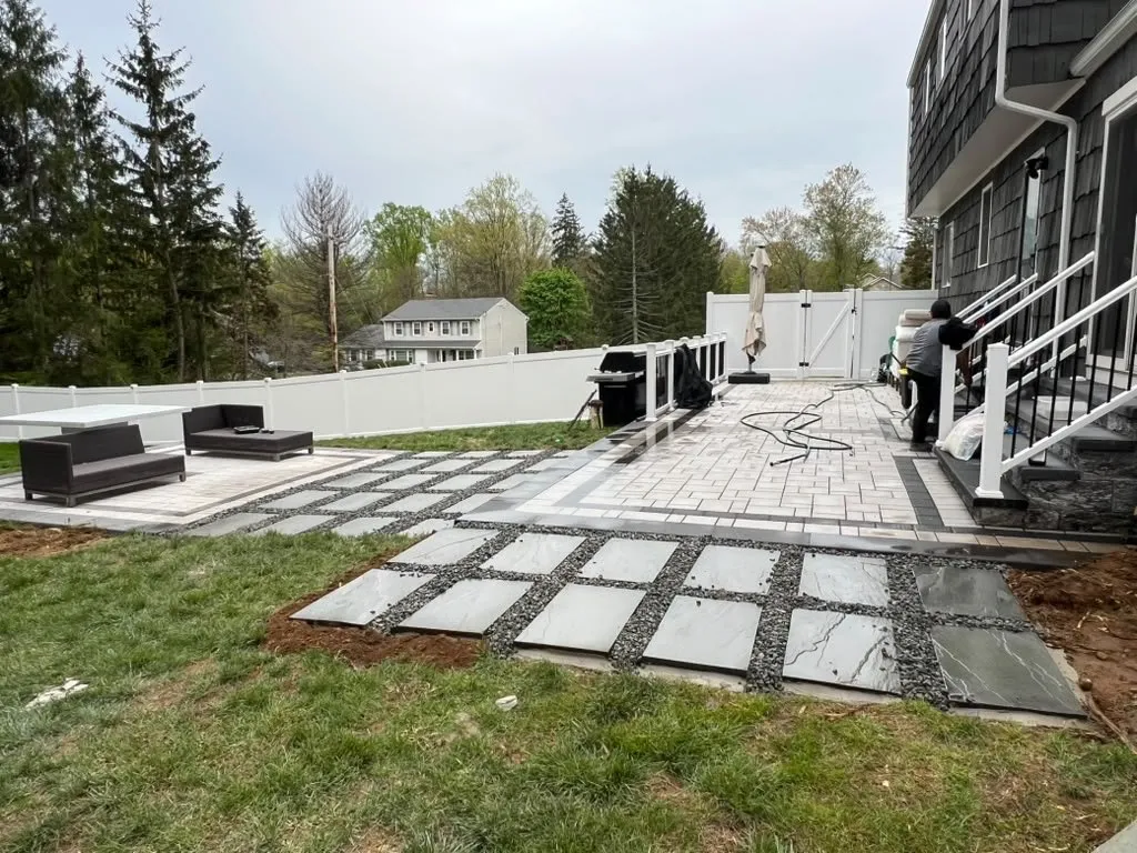 Gray paver patio with bluestone stepping stones set in gravel and outdoor seating