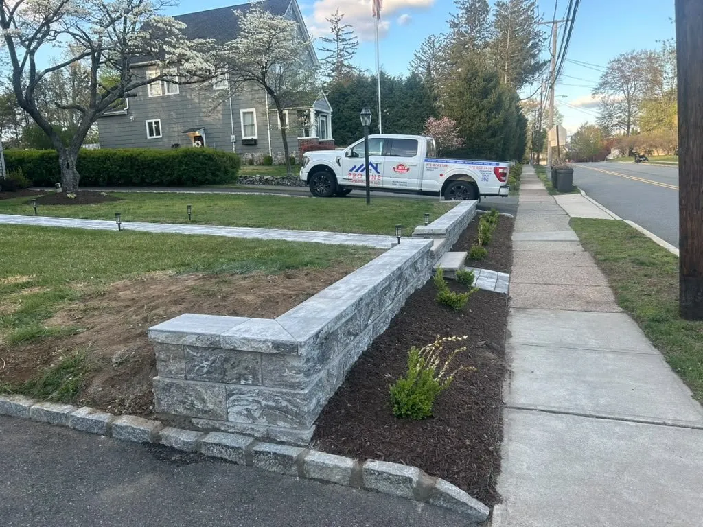 Natural stone front yard wall with matching stone curb along the driveway